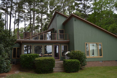 Example of a mid-sized green two-story wood exterior home design in Raleigh