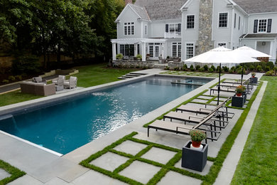 Design ideas for a large transitional backyard rectangular lap pool in New York with a hot tub and concrete pavers.