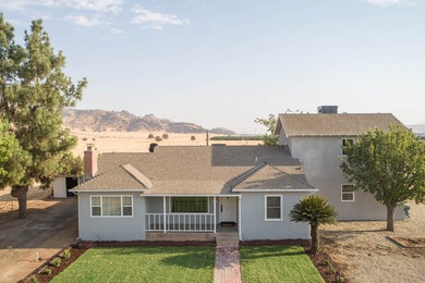 Mid-sized cottage gray two-story stucco exterior home photo in Other with a shingle roof