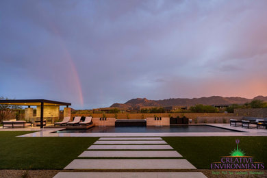 Photo of a large modern back formal partial sun pergola for summer in Phoenix with concrete paving and a metal fence.