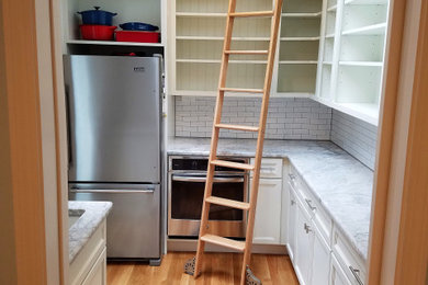 Example of a large transitional kitchen pantry design in Boston with an island