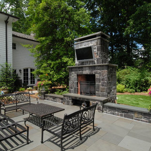 ニューヨークの巨大なヴィクトリアン調のおしゃれな裏庭のテラス (ファイヤーピット、天然石敷き、日よけなし) の写真