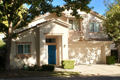 Inspiration for a mid-sized transitional beige two-story stucco exterior home remodel in Other with a tile roof