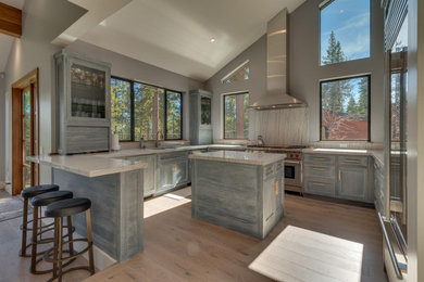 Huge minimalist u-shaped light wood floor, brown floor and vaulted ceiling kitchen pantry photo in Sacramento with shaker cabinets, gray cabinets, marble countertops, an island, multicolored countertops, an undermount sink, multicolored backsplash, marble backsplash and stainless steel appliances