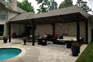 Inspiration for a backyard concrete paver patio remodel in Houston with a pergola