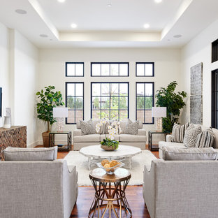 Photo of a medium sized mediterranean open plan living room in Orange County with white walls, medium hardwood flooring, a wall mounted tv and brown floors.