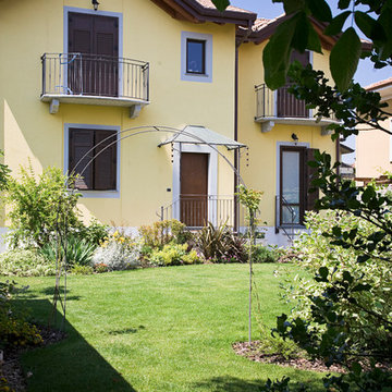 Il giardino davanti a casa, incorniciato da bordure in tinta con le facciate