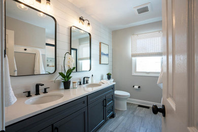 Example of a mid-sized minimalist kids' white tile and subway tile porcelain tile, brown floor and double-sink bathroom design in Philadelphia with recessed-panel cabinets, gray cabinets, a two-piece toilet, gray walls, an undermount sink, quartz countertops, white countertops and a built-in vanity