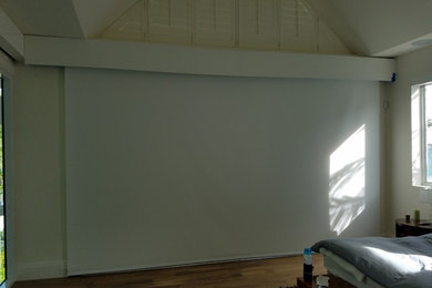 Cette photo montre une grande chambre parentale moderne avec un mur blanc.