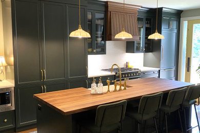 Inspiration for a small timeless medium tone wood floor open concept kitchen remodel in Toronto with a farmhouse sink, recessed-panel cabinets, green cabinets, quartz countertops, white backsplash, ceramic backsplash, paneled appliances and an island