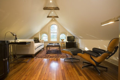 Example of an ornate enclosed medium tone wood floor family room design in Atlanta with beige walls and a corner tv