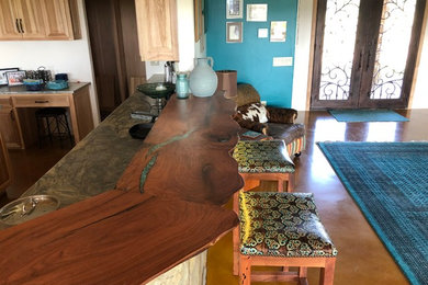 Inspiration for a large craftsman l-shaped brown floor and concrete floor eat-in kitchen remodel in Austin with a drop-in sink, light wood cabinets, wood countertops, stainless steel appliances, a peninsula, brown countertops and raised-panel cabinets