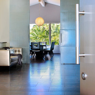 Idee per un grande ingresso industriale con pareti con effetto metallico, pavimento in gres porcellanato, una porta a due ante e una porta in metallo