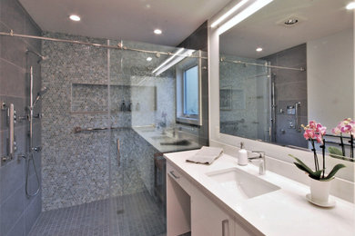 Minimalist master blue tile and porcelain tile porcelain tile, gray floor and double-sink sliding shower door photo in Philadelphia with flat-panel cabinets, white cabinets, a one-piece toilet, gray walls, an undermount sink, quartz countertops, white countertops, a niche and a built-in vanity