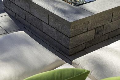 Inspiration for a mid-sized contemporary backyard brick landscaping in Montreal with a fire pit for summer.