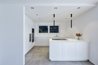 This is an example of a contemporary kitchen in Dusseldorf with flat-panel cabinets, white cabinets and with island.