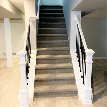 Modern stairs with wool carpeting and matte black spindles
