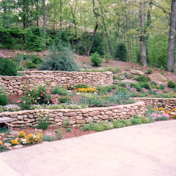 Curved stone retaining walls and huge boulders on hill