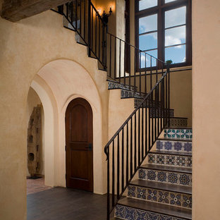 Imagen de escalera mediterránea con escalones de madera y contrahuellas con baldosas y/o azulejos