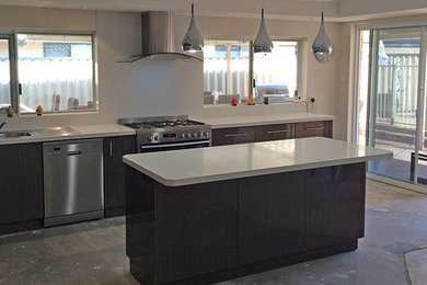 This is an example of a mid-sized contemporary l-shaped open plan kitchen in Perth with an undermount sink, flat-panel cabinets, dark wood cabinets, granite benchtops, stainless steel appliances and with island.
