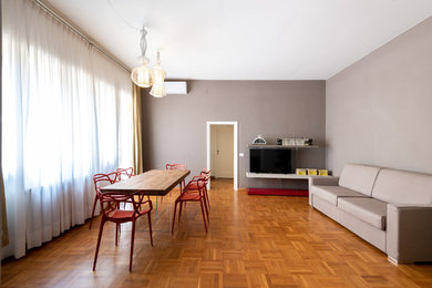 Idee per una grande sala da pranzo aperta verso il soggiorno moderna con pareti grigie, parquet chiaro e pavimento marrone