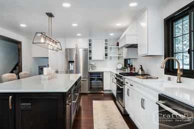 Large elegant l-shaped medium tone wood floor and brown floor eat-in kitchen photo in Seattle with an undermount sink, recessed-panel cabinets, white cabinets, quartz countertops, white backsplash, subway tile backsplash, stainless steel appliances, an island and white countertops