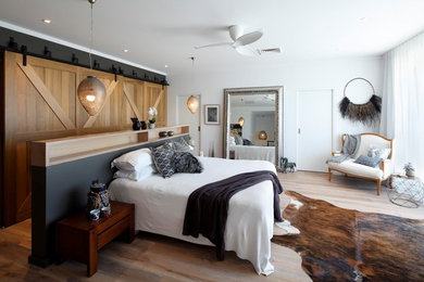 Inspiration for a large modern master bedroom in Sydney with white walls and light hardwood floors.