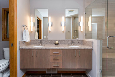 This is an example of a modern master bathroom in Denver with flat-panel cabinets, medium wood cabinets, beige tile, beige walls, ceramic floors, an undermount sink, engineered quartz benchtops, brown floor and a hinged shower door.