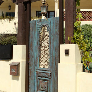 Photo of a large mediterranean entryway in Los Angeles with a single front door, a blue front door, beige walls, concrete floors and grey floor.