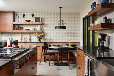 Inspiration for a mid-sized 1950s galley gray floor eat-in kitchen remodel in Minneapolis with flat-panel cabinets, an island, a farmhouse sink, medium tone wood cabinets, gray backsplash, stainless steel appliances and brown countertops