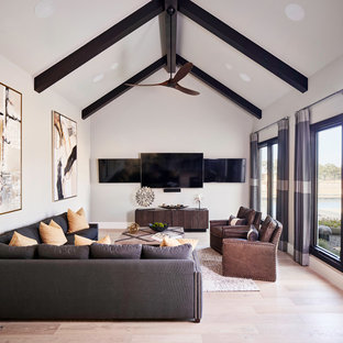 Aménagement d'une salle de cinéma classique avec un mur blanc, un sol en bois clair et un téléviseur fixé au mur.