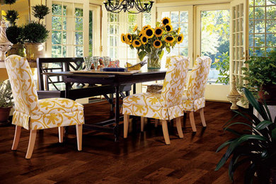 Example of a mid-sized classic medium tone wood floor enclosed dining room design in Other with yellow walls and no fireplace