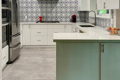 Mid-sized trendy u-shaped porcelain tile and gray floor kitchen photo in Miami with a single-bowl sink, flat-panel cabinets, white cabinets, quartz countertops, multicolored backsplash, porcelain backsplash, stainless steel appliances, a peninsula and multicolored countertops