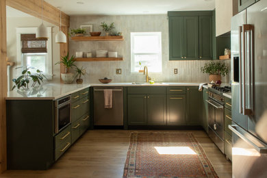 Inspiration for a mid-sized transitional u-shaped medium tone wood floor and brown floor eat-in kitchen remodel in Baltimore with an undermount sink, shaker cabinets, green cabinets, quartz countertops, white backsplash, stone tile backsplash, stainless steel appliances, a peninsula and white countertops