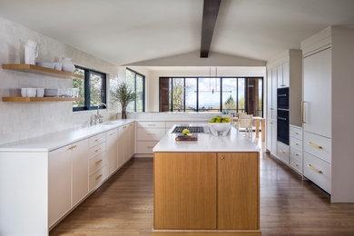 Large contemporary eat-in kitchen in Portland with an undermount sink, flat-panel cabinets, white cabinets, quartz benchtops, white splashback, panelled appliances, with island, white benchtop and medium hardwood floors.