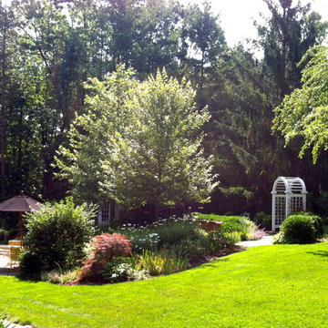 Backyard Perennial Garden with Stone Patio and Wooden Arbor