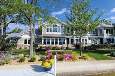 Example of a huge classic green two-story mixed siding exterior home design with a metal roof