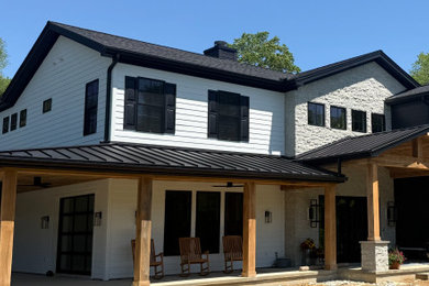 Inspiration for a large farmhouse white two-story mixed siding and clapboard exterior home remodel in Philadelphia with a metal roof and a black roof