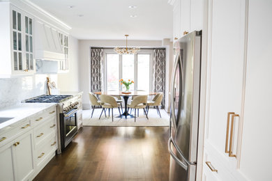 Open concept kitchen - mid-sized transitional galley medium tone wood floor and brown floor open concept kitchen idea in Toronto with an undermount sink, shaker cabinets, white cabinets, marble countertops, white backsplash, marble backsplash, black appliances, an island and white countertops