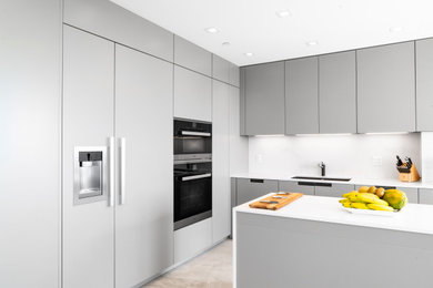 Design ideas for a large contemporary l-shaped eat-in kitchen in Miami with a single-bowl sink, flat-panel cabinets, grey cabinets, marble benchtops, white splashback, marble splashback, stainless steel appliances, with island and white benchtop.