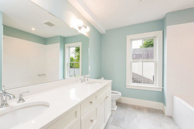 Bathroom - mid-sized transitional master white tile and subway tile ceramic tile and gray floor bathroom idea in Manchester with shaker cabinets, white cabinets, a two-piece toilet, blue walls, an undermount sink and solid surface countertops