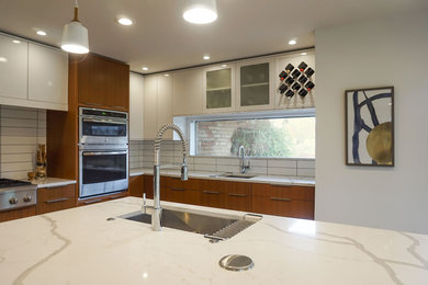 Inspiration for a mid-sized modern l-shaped medium tone wood floor and brown floor kitchen remodel in Boise with an undermount sink, flat-panel cabinets, medium tone wood cabinets, quartzite countertops, white backsplash, ceramic backsplash, stainless steel appliances and an island