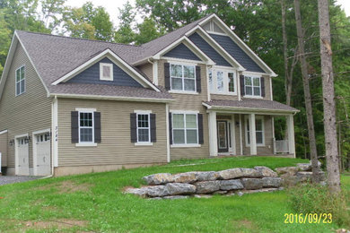 Ejemplo de fachada de casa multicolor de estilo americano grande de dos plantas con revestimiento de vinilo, tejado a dos aguas y tejado de teja de madera
