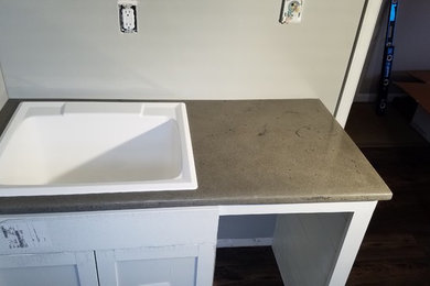 Example of a mid-sized cottage vinyl floor and gray floor dedicated laundry room design in Philadelphia with an utility sink, concrete countertops, gray walls and gray countertops