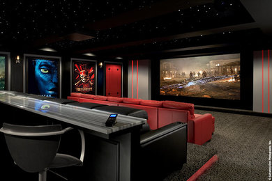 Large traditional enclosed home theatre in New York with multi-coloured walls, carpet, a built-in media wall and grey floor.