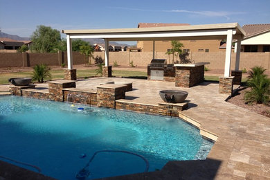 Inspiration for a mid-sized backyard stone landscaping in Phoenix.