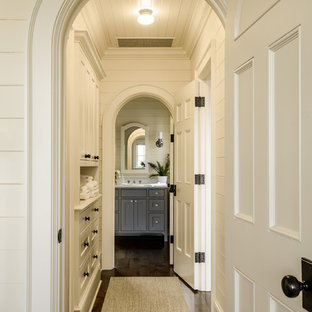 Bild på en vintage hall, med vita väggar, mörkt trägolv och brunt golv