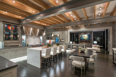 Example of a transitional dark wood floor and brown floor open concept kitchen design in Philadelphia with glass-front cabinets, stainless steel cabinets, white backsplash, stainless steel appliances and an island