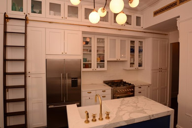 Inspiration for a mid-sized transitional l-shaped open concept kitchen remodel in New York with a farmhouse sink, shaker cabinets, white cabinets, marble countertops, white backsplash, brick backsplash and an island