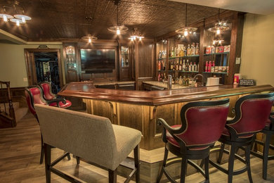 Seated home bar - large traditional u-shaped porcelain tile seated home bar idea in Other with an undermount sink, raised-panel cabinets, dark wood cabinets and quartz countertops